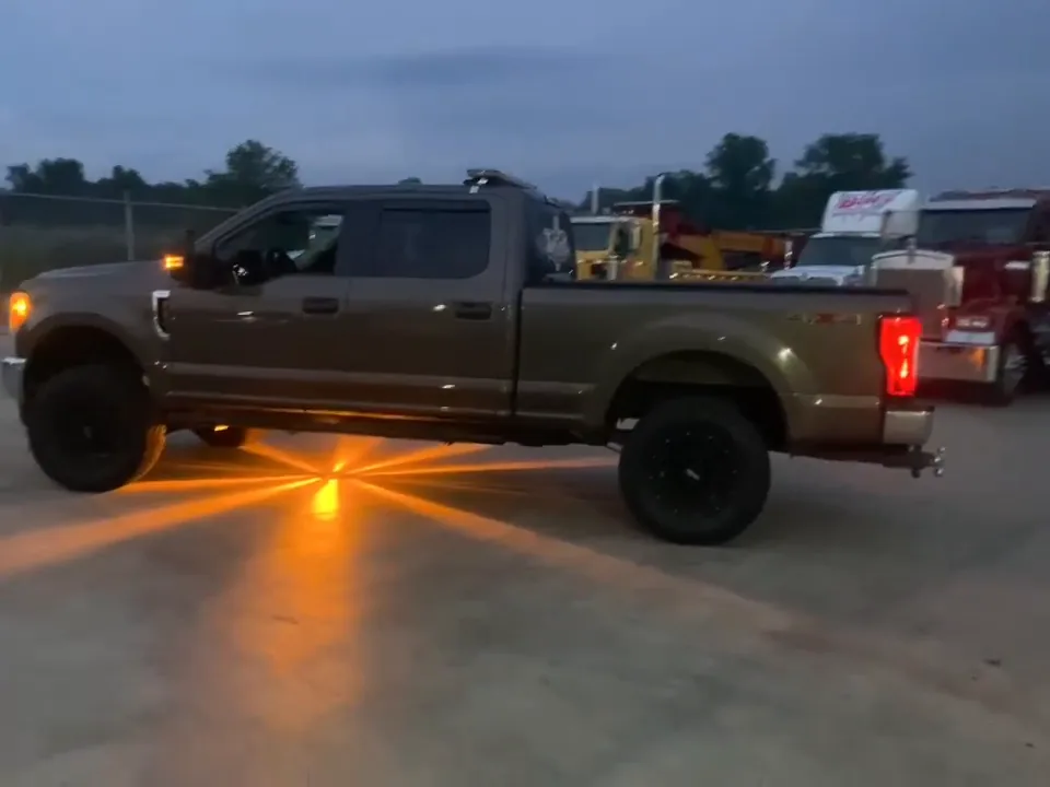 Pickup truck with amber radial lighting on the pavement at dusk.