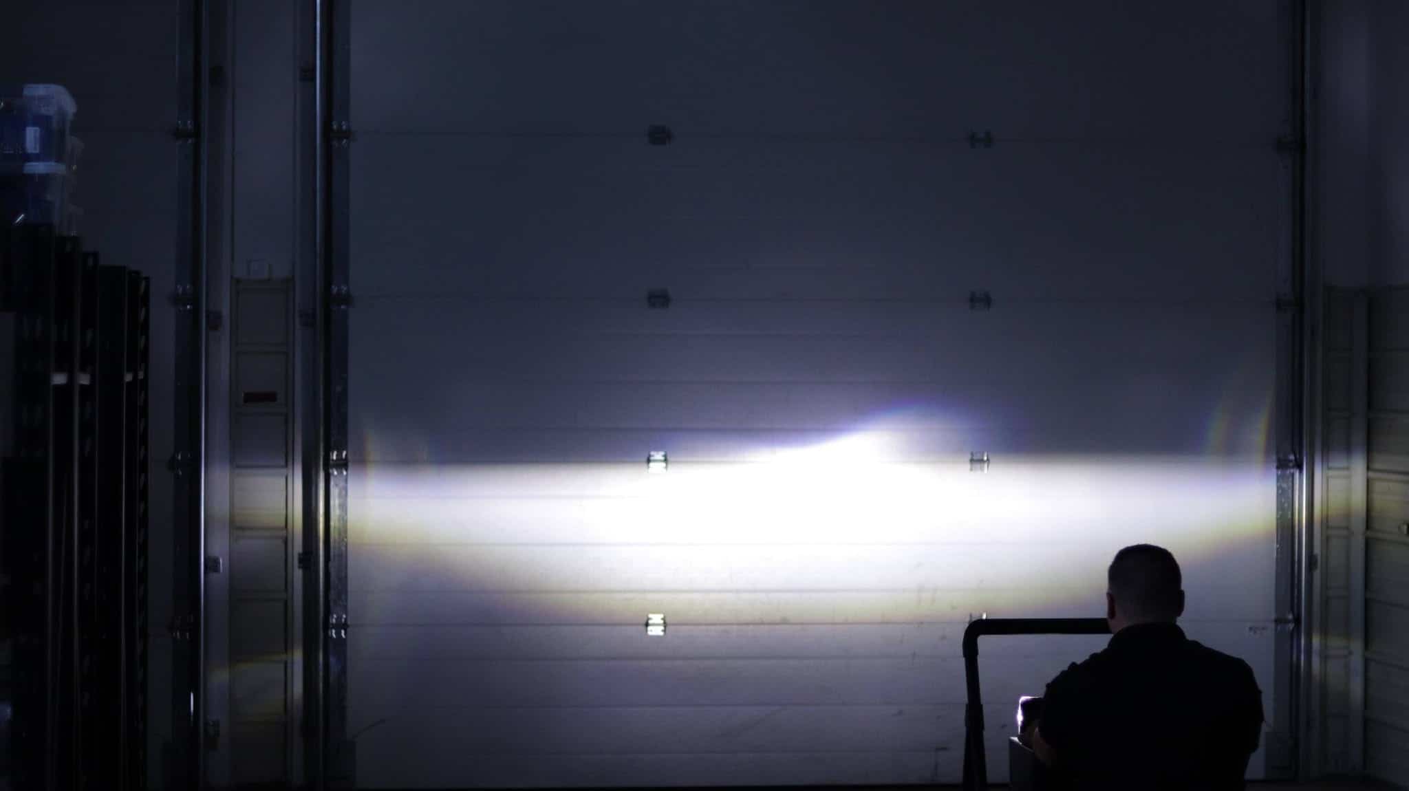 Headlight beam across a garage door with a raised central boundary in BTS Lighting's comparison