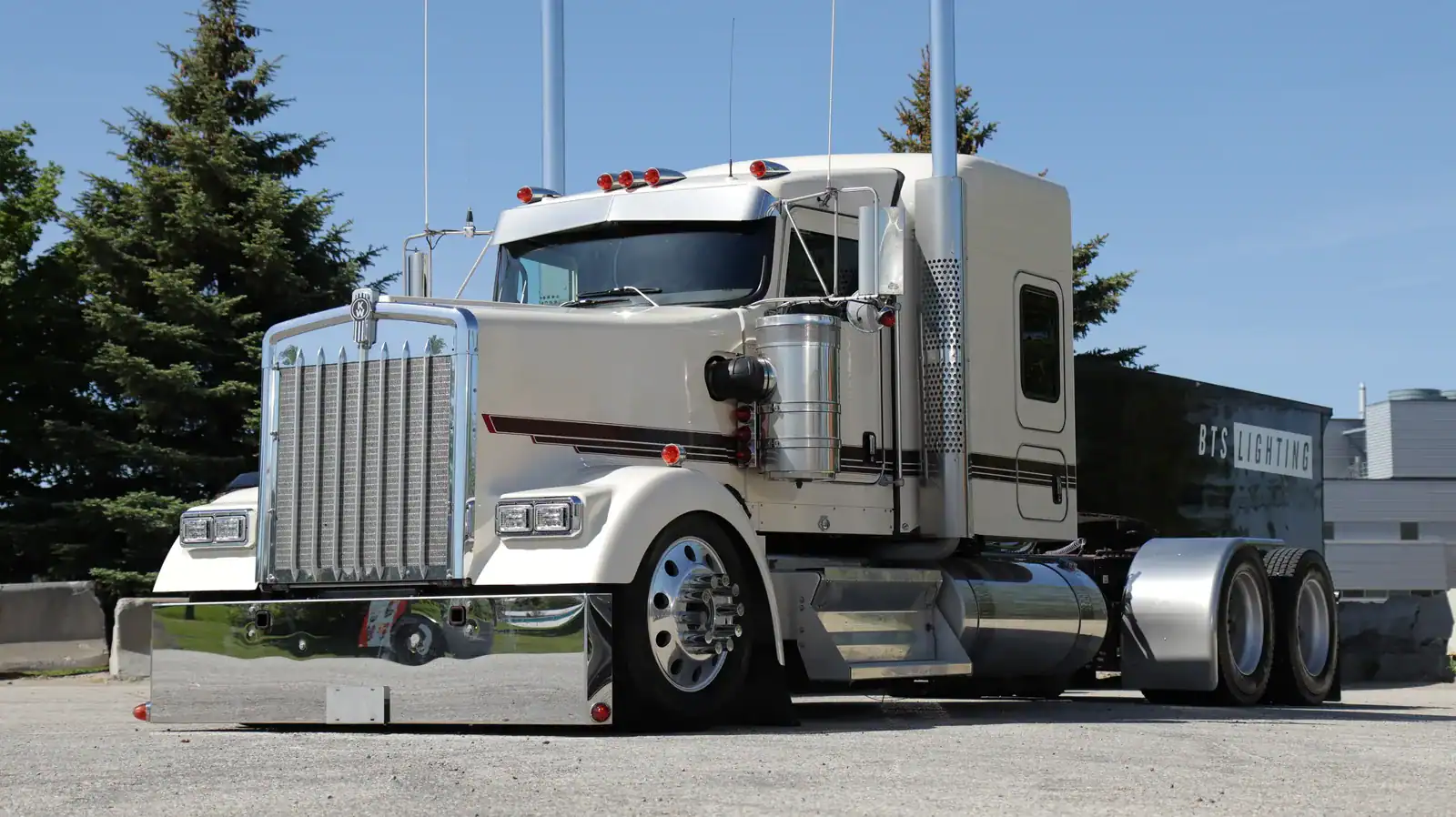 Closer front-quarter view of the cream Kenworth W900L, chrome grille and rectangular EVO-X headlights