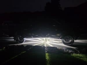 White Glass Is Class Gen 2 watermelon-light starbursts glowing beneath a black custom pickup