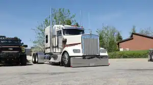 Cream Kenworth W900L with chrome J.W. Speaker EVO-X headlights, photographed from the front quarter