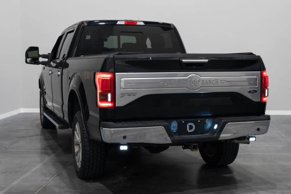 Manufacturer mounting-location photograph on the 2015–2020 F-150, showing the earlier two-inch housing. Current C2 2.0 kit hardware is shown separately.