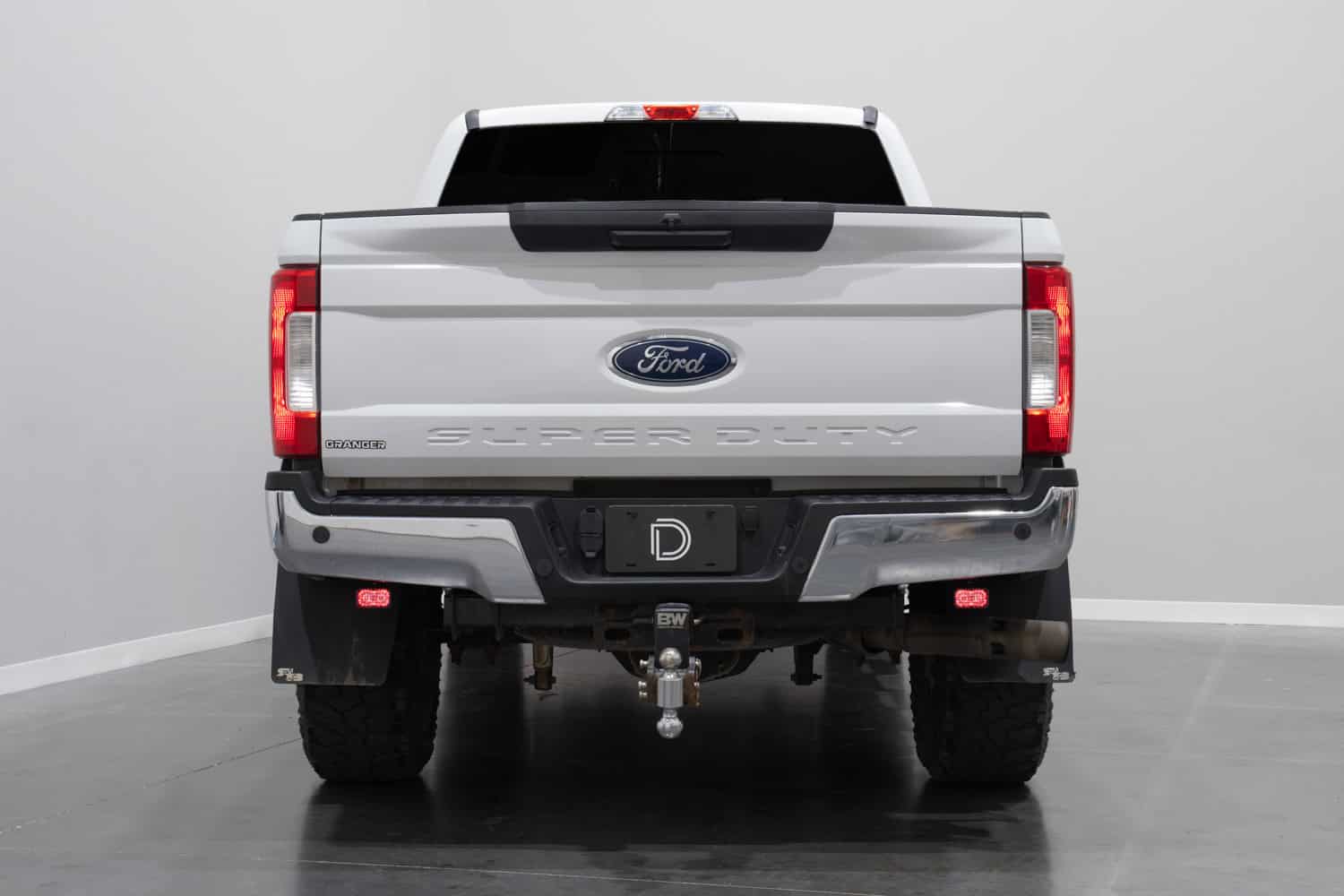 Diode Dynamics SSC2 red backlights below a Ford Super Duty rear bumper
