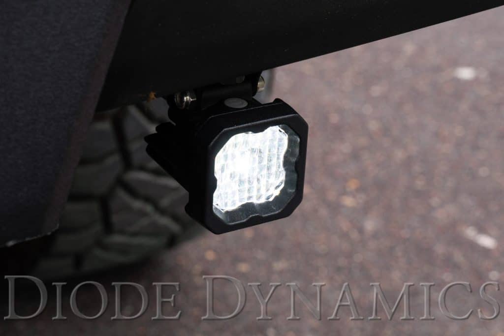 Diode Dynamics Stage Series Reverse Light Kit For 2016-2023 Toyota Tacoma C1 100 C1 pods installed below the 2016–2023 Tacoma rear bumper, white Flood main beam on.
