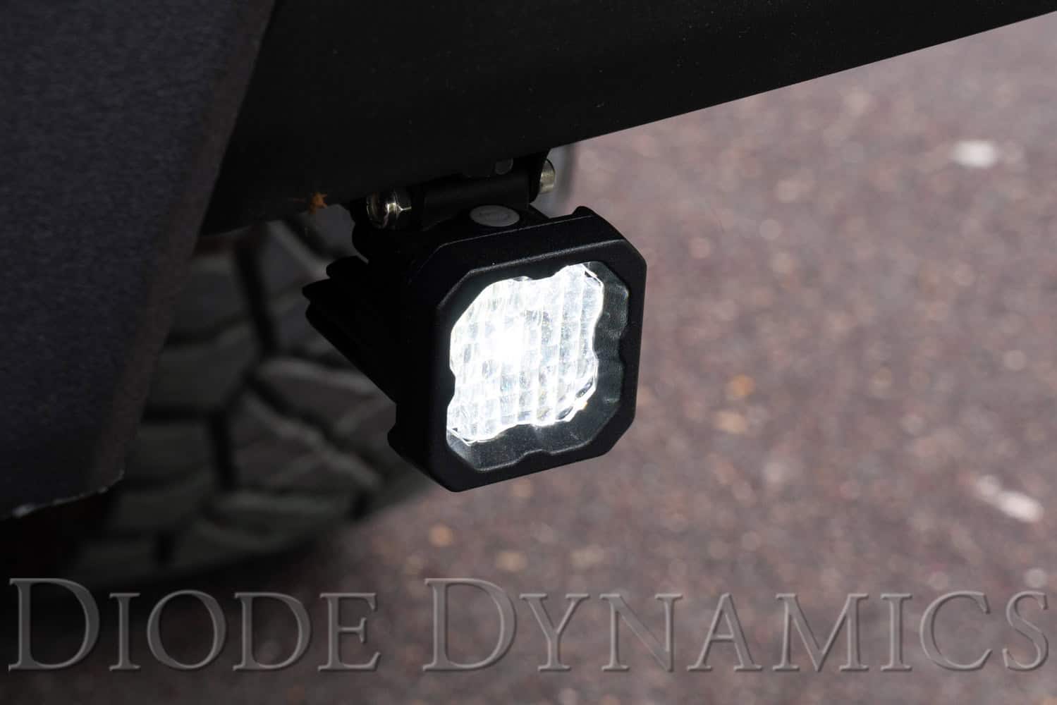 C1 pods installed below the 2016–2023 Tacoma rear bumper, white Flood main beam on.