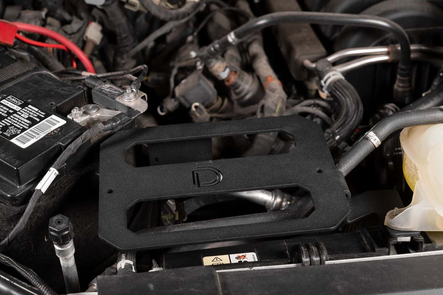 Diode Dynamics D-Switch Hub Mounting Kit For 2021-2026 Ford F-150 12 DD8572 bracket installed beside the F-150 battery.